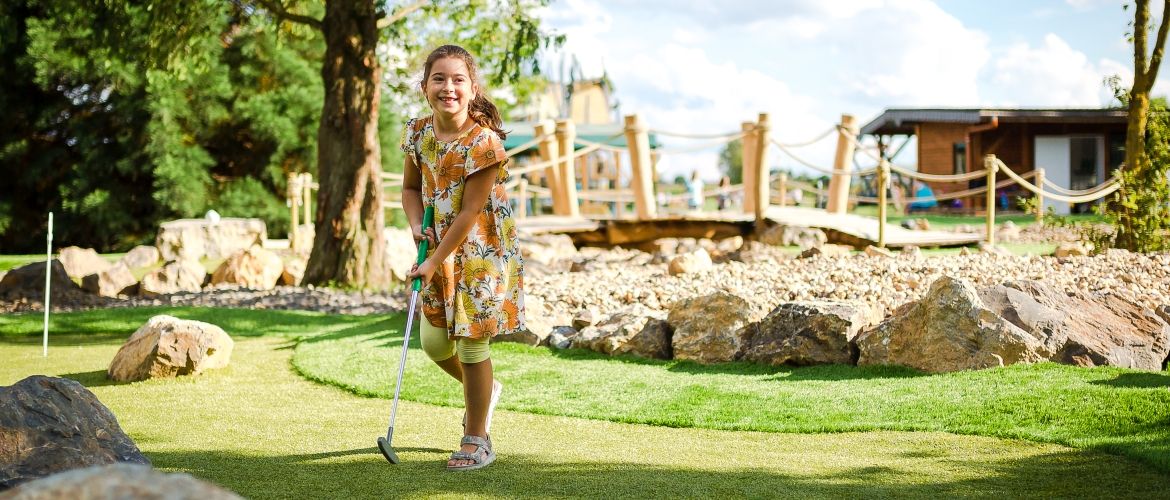 Ein Mädchen spielt Adventure-Golf im Bubenheimer Spieleland
