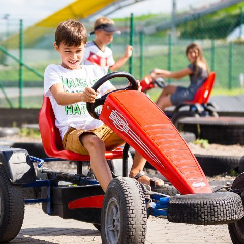 Junge beim Gokart fahren auf dem Abenteuerspielplatz