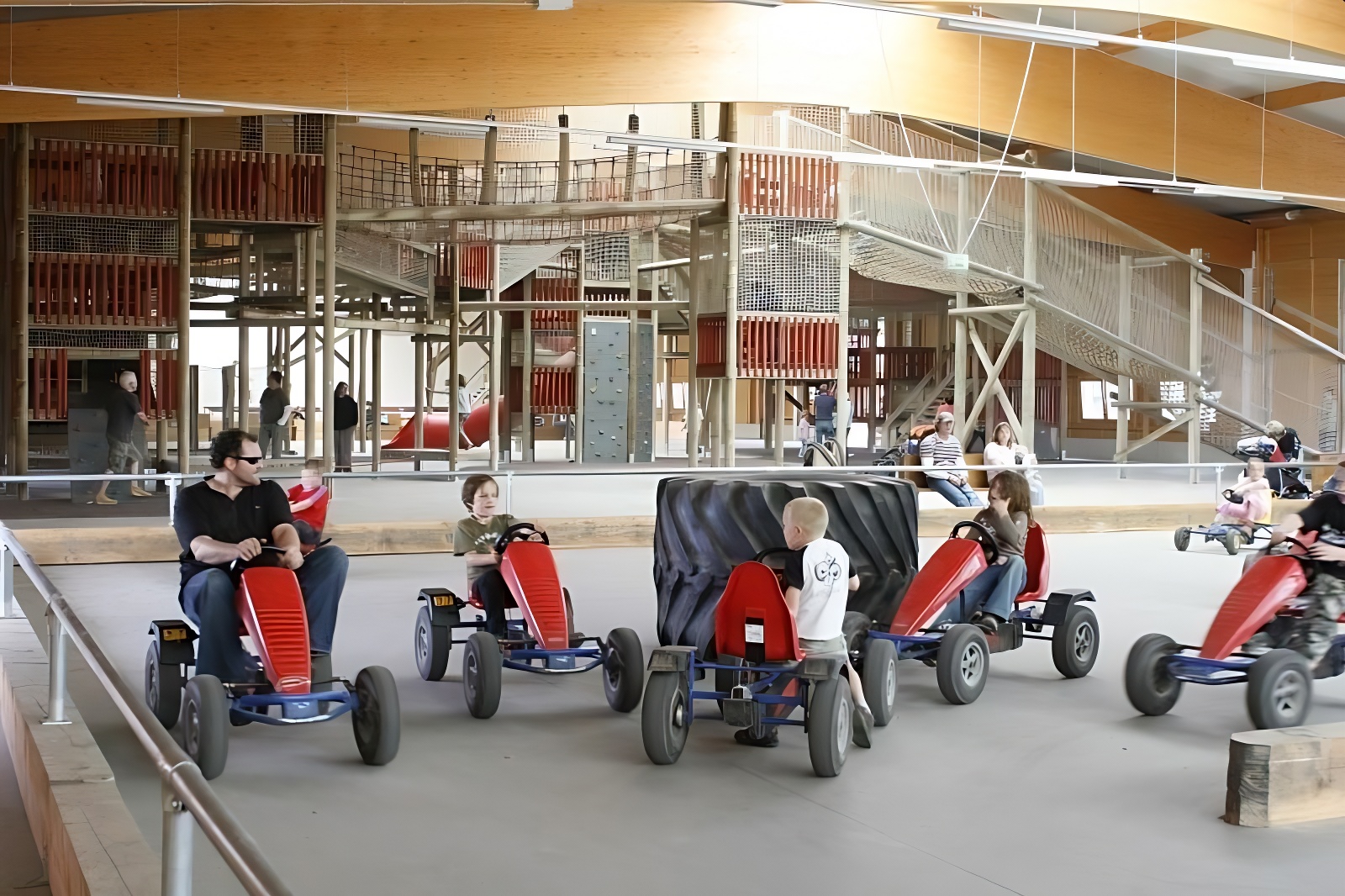 Innenansicht der Allwetterhalle. Im Vordergrund sieht man einen Mann und mehrere Kinder in Gokarts.