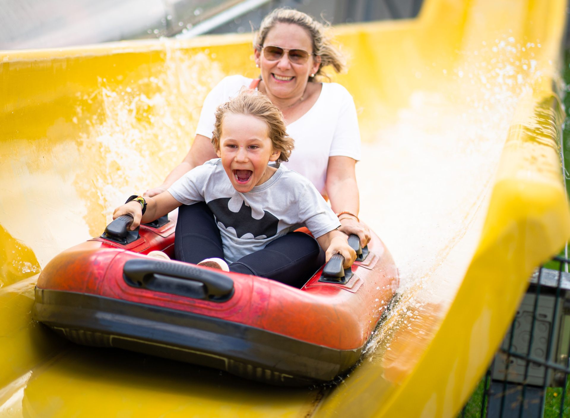 Mutter und Sohn auf der Boots-Wasserrutsche