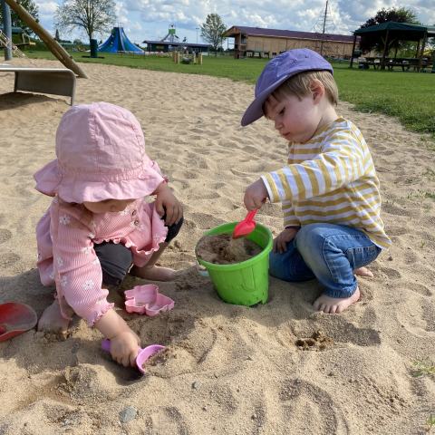 2 Kleinkinder spielen im Sand