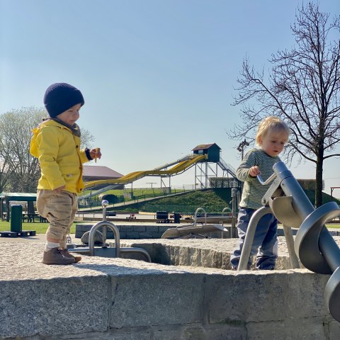 zwei Kleinkinder am Wasserspielplatz